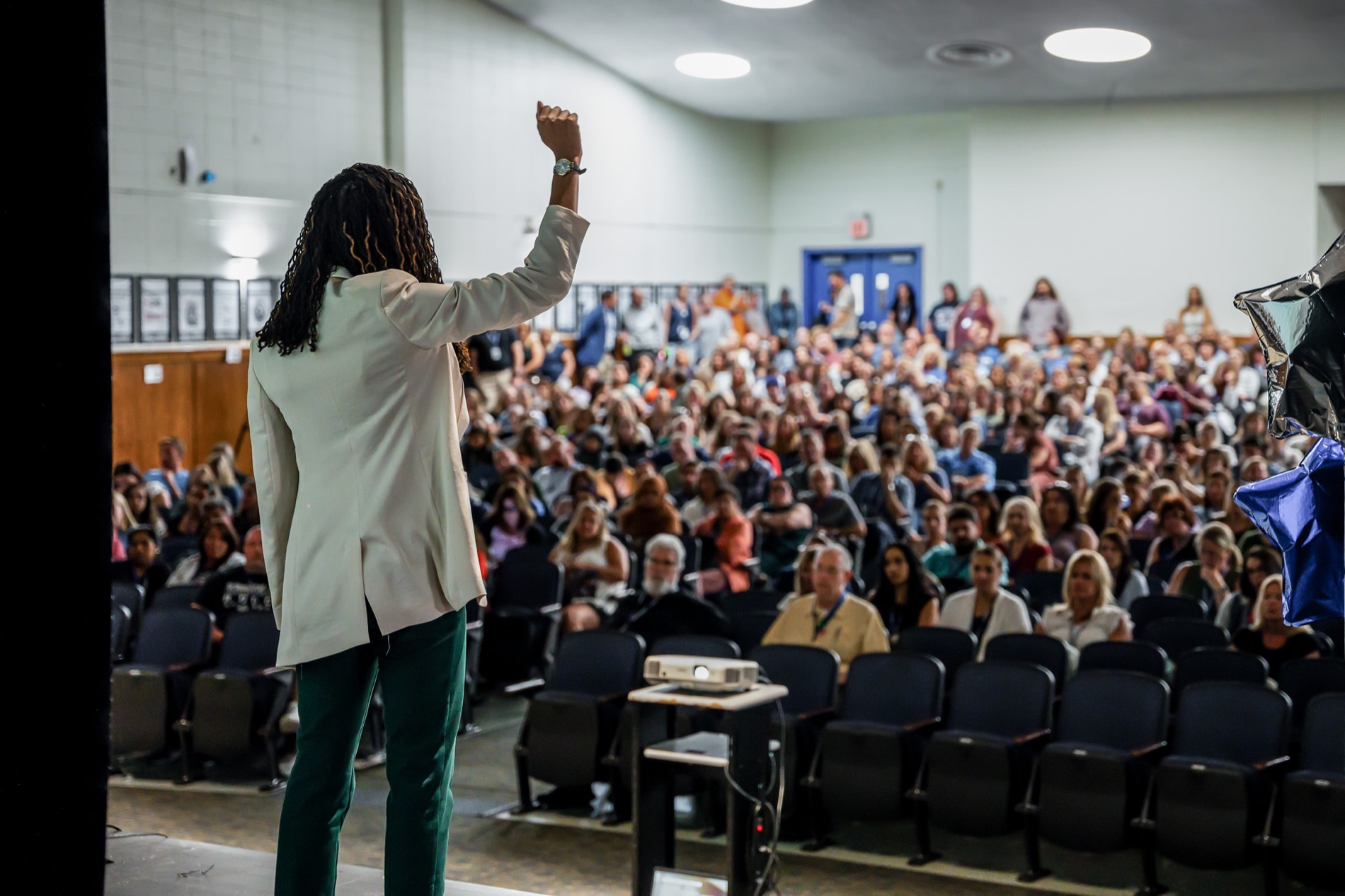 Dr. Joyce on stage facing the audience, fist raised